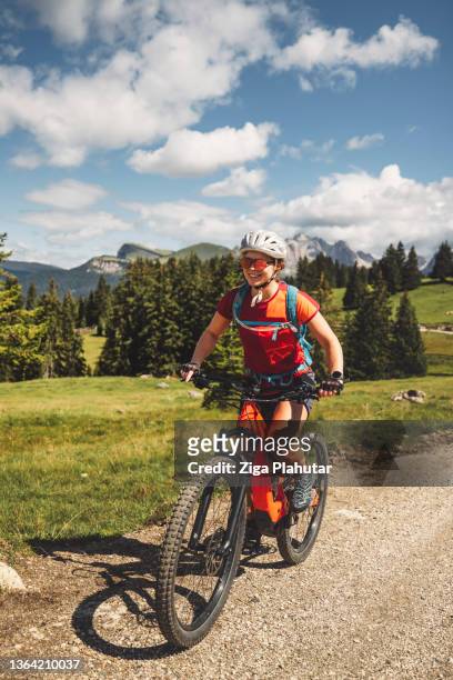 active caucasian female on mountain bike - exploring dolomites - claus lange stock pictures, royalty-free photos & images