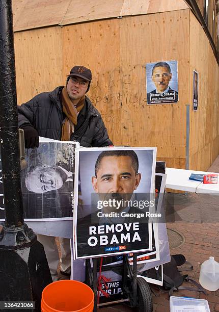 Posters depicting President Barack Obama with an Adolf Hitler mustache are viewed at a Tremont Street construction site on December 17, 2011 in...