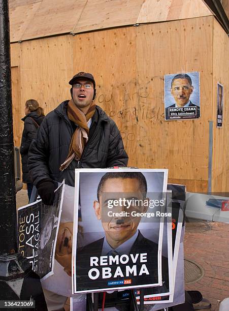 Posters depicting President Barack Obama with an Adolf Hitler mustache are viewed at a Tremont Street construction site on December 17, 2011 in...