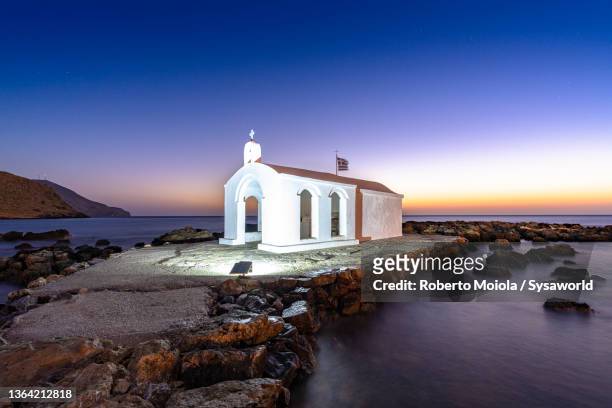dusk over the small chapel by the sea, greece - iglesia de agios nikolaos fotografías e imágenes de stock