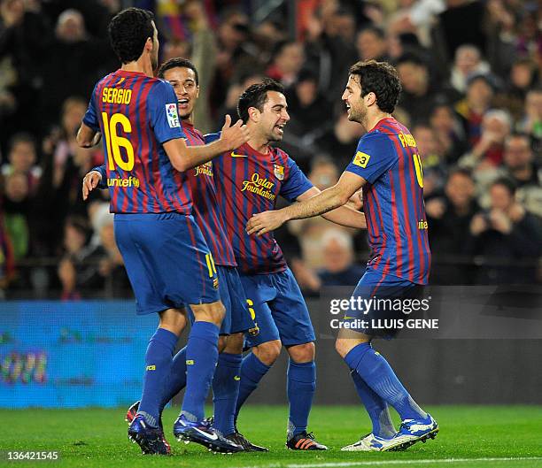 Barcelona's forward Cesc Fabregas celebrates with Barcelona's midfielder Xavi Hernandez , Barcelona's midfielder Thiago Alcántara and Barcelona's...