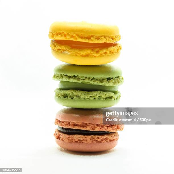 close-up of stacked macaroons against white background - macaroon stock pictures, royalty-free photos & images