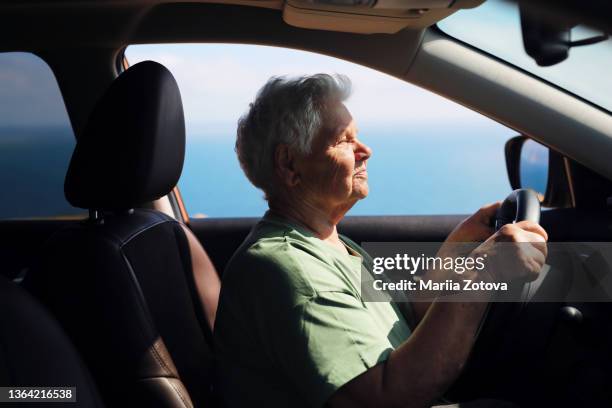 the old lady enjoys life, travels by car and is happy to recover from her illness. a new life - aging happy stockfoto's en -beelden