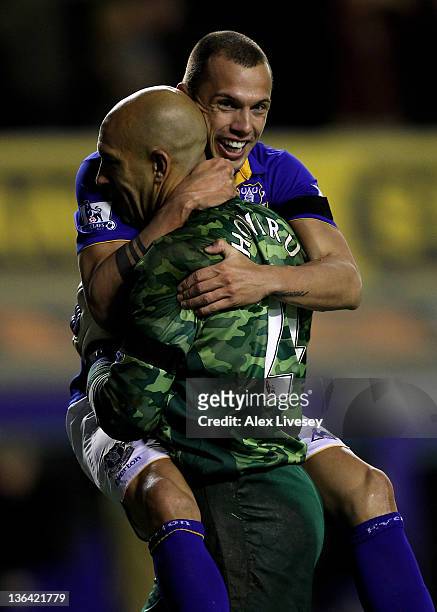 Tim Howard of Everton is embraced by team mate John Heitinga after scoring the opening goal during the Barclays Premier League match between Everton...