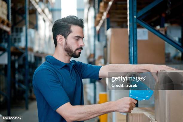 homme travaillant dans un entrepôt - blue polo shirt photos et images de collection