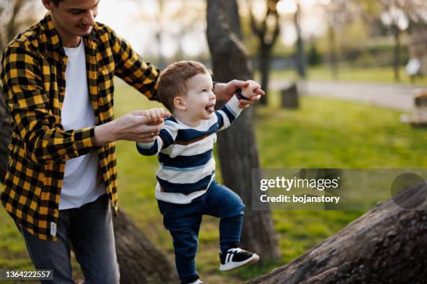 papa, hilf mir, auf einen baum zu klettern - klettern park stock-fotos und bilder