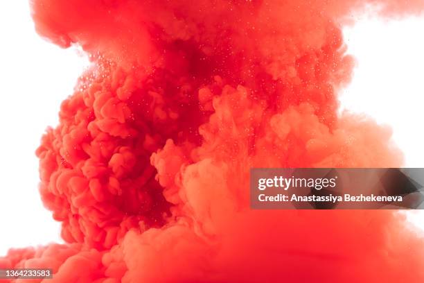 vertical splash of red paint in water against white background - ink cloud stock pictures, royalty-free photos & images