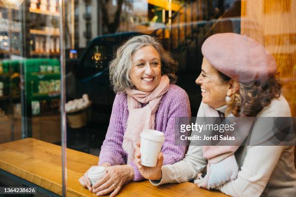 two senior women drinking coffee in a coffee shop - two cups of coffee stock pictures, royalty-free photos & images