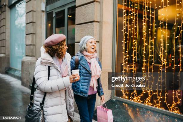 two senior women walking down the street - winter barcelona stock pictures, royalty-free photos & images