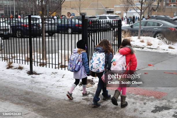 Students walk to A. N. Pritzker elementary school on January 12, 2022 in Chicago, Illinois. Students in Chicago public schools are returning to...