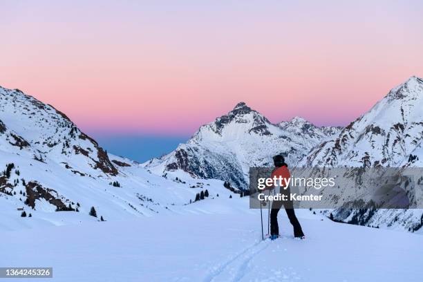 skifahrer im skigebiet lech nach sonnenuntergang - österreichische zentralalpen stock-fotos und bilder