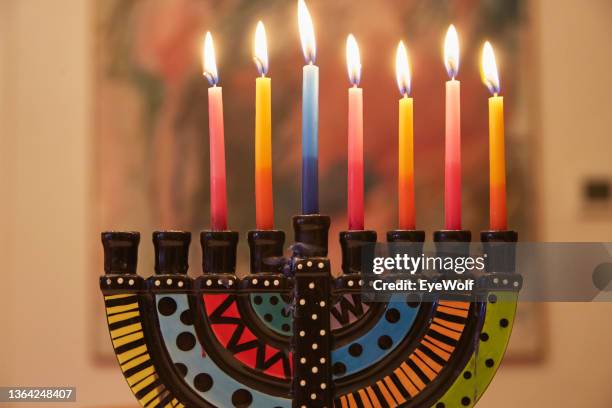 low angle shot of a colorful ceramic menorah burning candles on hanukah - menorah stock pictures, royalty-free photos & images