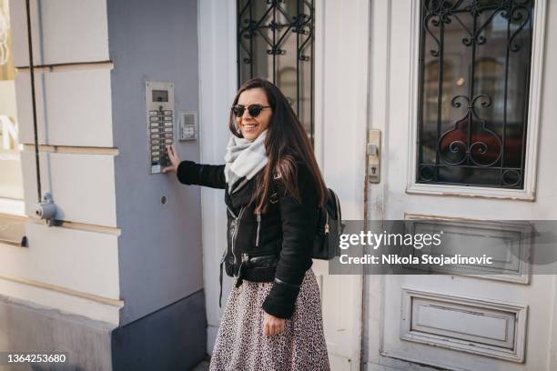 a woman talking on the intercom - door bell 個照片及圖片檔