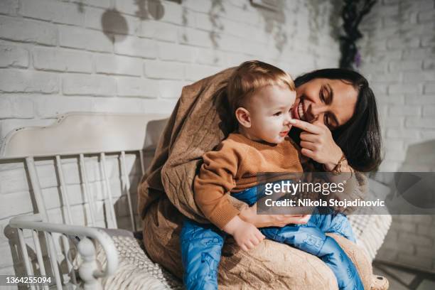 schöne junge mutter mit baby kind verbringen zeit in einem café - gezahnt stock-fotos und bilder