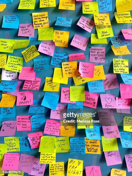 wall of well wishes filled with colorful sticky notes with hand written words of positivity and encouragement. - encouragement letter stock pictures, royalty-free photos & images