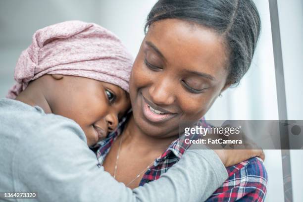 boy with cancer hugging his mom - childhood cancer stock pictures, royalty-free photos & images
