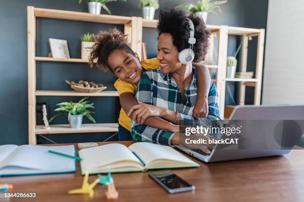 mother is working from home and her daughter is embracing her - working mother 個照片及圖片檔