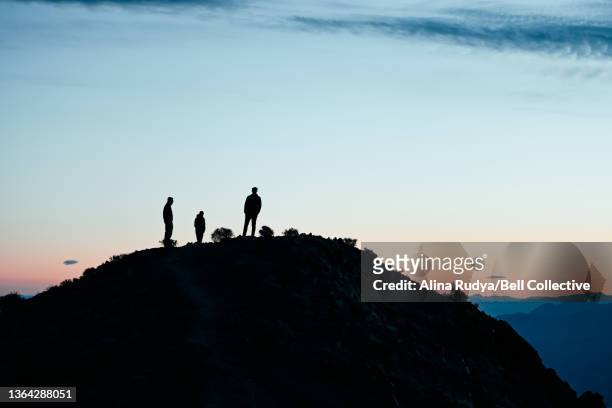 3 people standing on a top of a hill at sunset - great basin fotografías e imágenes de stock