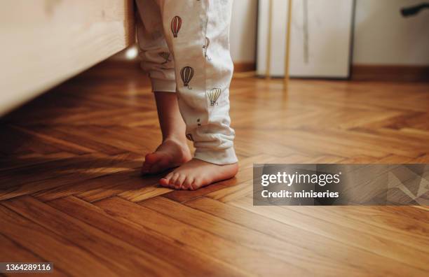 close up shot of child's legs on the wooden floor - parket stockfoto's en -beelden
