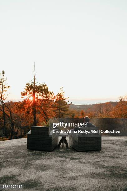 Man sitting in an armchair watching sunset