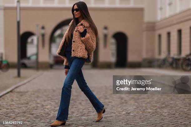 Jill Asemota wearing brown vintage teddy jacket, Frame blue jeans, brown suede Aeyde boots, and black Celine shades on January 11, 2022 in Berlin,...