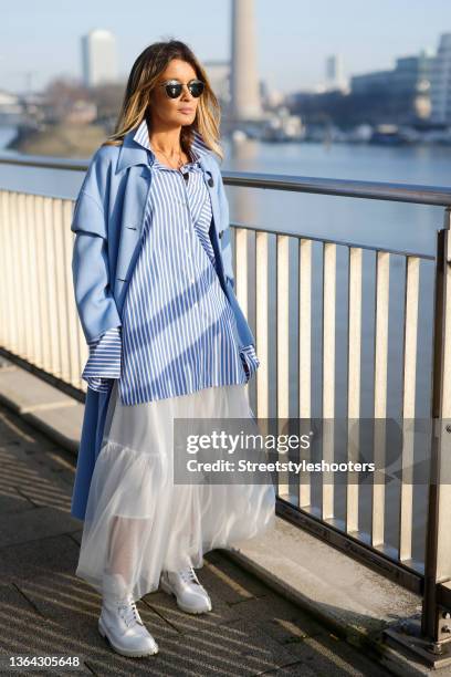 Influencer Gitta Banko wearing a white and light blue striped blouse by Emanou, light blue coat by Arma, a white maxi skirt by Lorena Antoniazzi,...