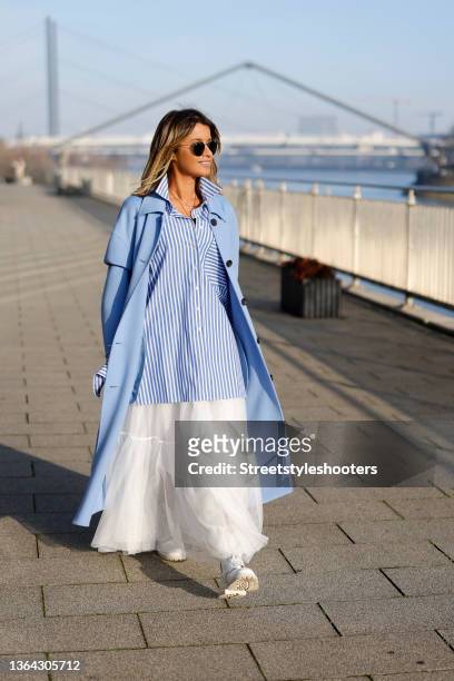Influencer Gitta Banko wearing a white and light blue striped blouse by Emanou, light blue coat by Arma, a white maxi skirt by Lorena Antoniazzi,...