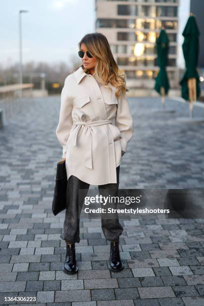 Influencer Gitta Banko wearing a black tie dye t-shirt by Paige, a beige coat by Arma, grey denim jeans pants by rag & bone, black vinyl boots by...