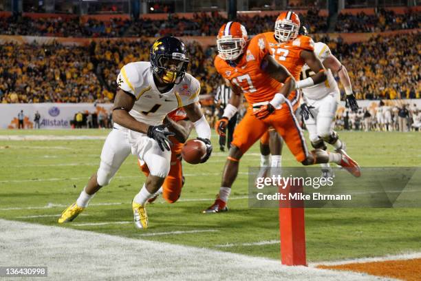 Tavon Austin of the West Virginia Mountaineers scores an 8-yard rushing touchdown in the first quarter against Bashaud Breeland of the Clemson Tigers...
