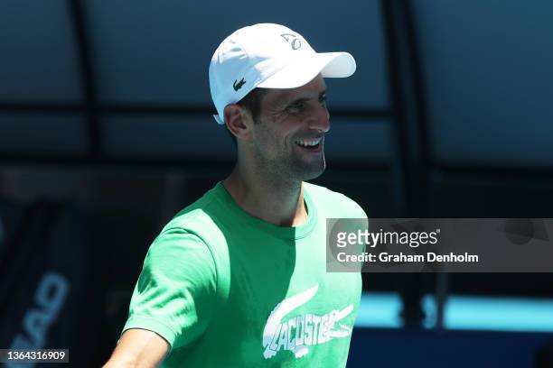 Novak Djokovic of Serbia smiles during a practice session ahead of the 2022 Australian Open at Melbourne Park on January 13, 2022 in Melbourne,...