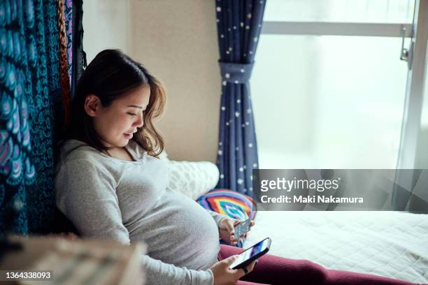 pregnant female shopping online. - woman smartphone family ストックフォトと画像
