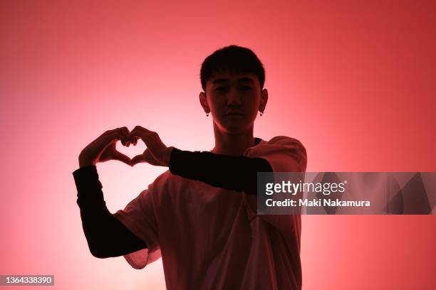 gen z men are making hearts by hand. - gen i stock pictures, royalty-free photos & images