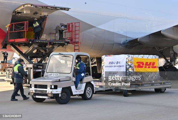 Ground crew move pallets of a shipment of Pfizer's antiviral COVID-19 pills, Paxlovid, as they arrive at a Incheon International Airport cargo...