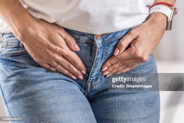 ovaries or groins pain with detail of female hands holding her underbelly. - menstrual pain stockfoto's en -beelden
