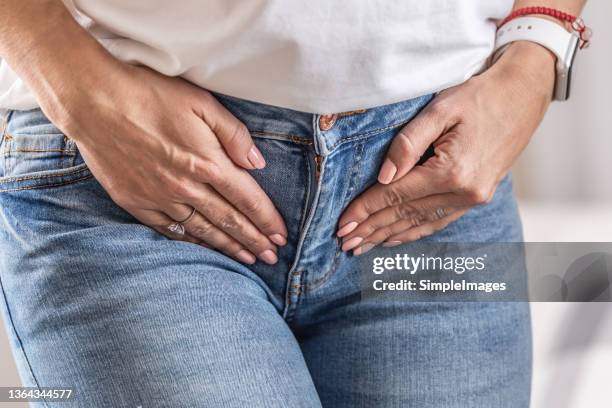 ovaries or groins pain with detail of female hands holding her underbelly. - woman crotch stock pictures, royalty-free photos & images