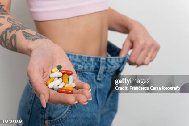 woman show slimming tablets in the hand - anorexie nerveuse photos et images de collection