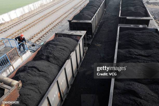 Worker shovels coal onto a freight train at a coal mine of Huaibei Coal Mine Inc. On January 12, 2022 in Huaibei, Anhui Province of China.