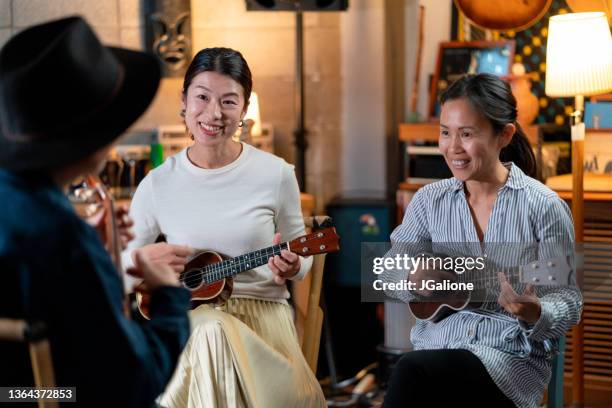 group ukulele lesson with two mature students - ukulele stock pictures, royalty-free photos & images