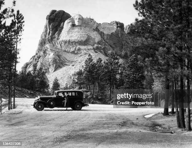 Mount Rushmore under construction with the face of President George Washington nearing completion in South Dakota, USA, circa 1930. In the foreground...