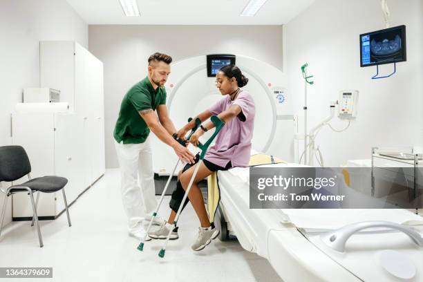 ct technician assisting injured patient in hospital - arzthelferin stock-fotos und bilder