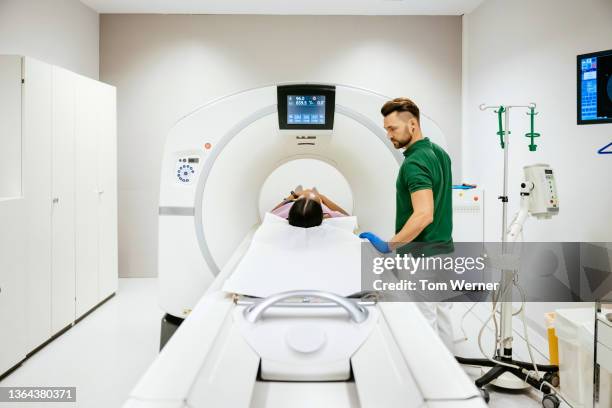 frontal view of mechanical bed attached to ct scanner orifice - cat scan machine stock pictures, royalty-free photos & images