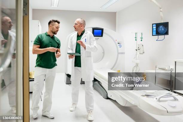 doctor talking to nurse in ct suite - green trousers stock pictures, royalty-free photos & images