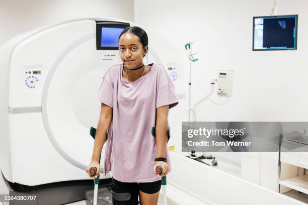 portrait of patient with leg injury in ct scanning room - lila shorts stock-fotos und bilder