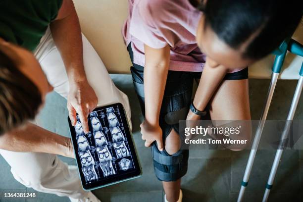injured woman talking to nurse after ct scan in hospital - orthopaedic equipment imagens e fotografias de stock