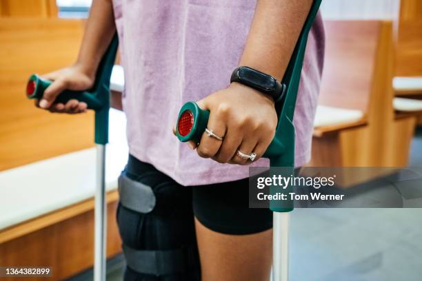 close up of woman holding crutches - crutch stock-fotos und bilder