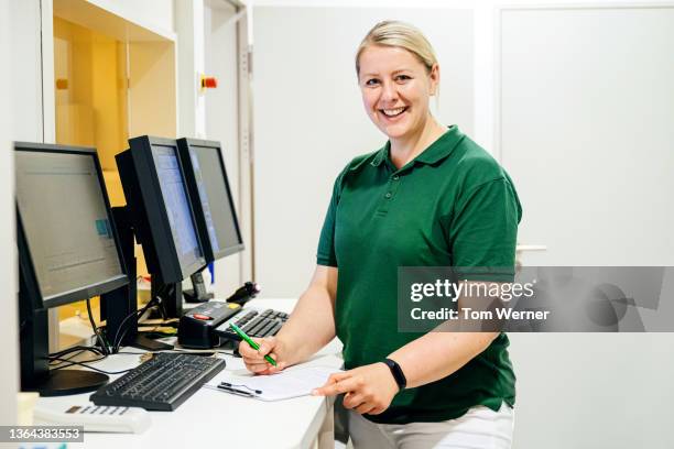 portrait of radiology technician smiling - polohemd stock-fotos und bilder