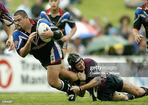 Mark Tookey of the Warriors is tackled by Steve Menzies of the Eagles during the round 25 NRL match between the Northern Eagles and the New Zealand...