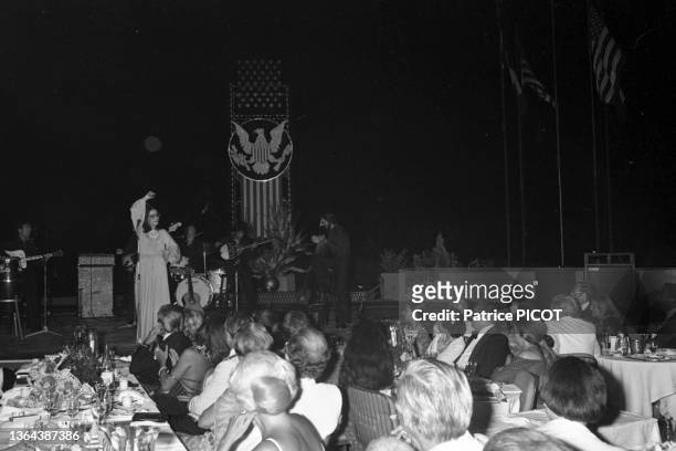 Nana Mouskouri sur scène la fête de l'Independence Day au Palm Beach de Cannes le 7 juillet 1977