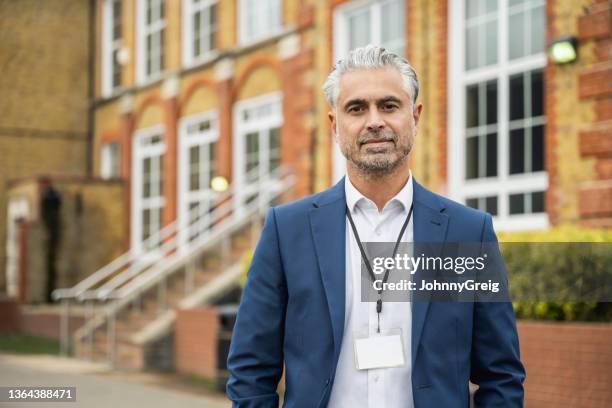 multiracial male principal standing outdoors on campus - trainer stockfoto's en -beelden