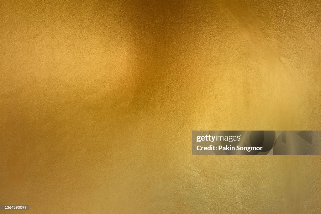 Gold color with old grunge wall concrete texture as background.